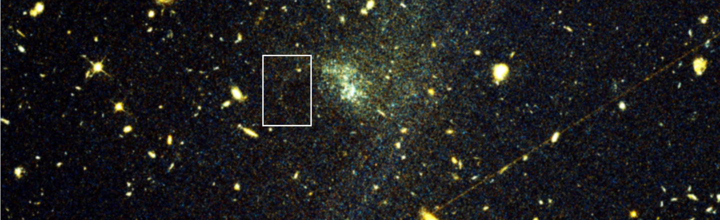 This image shows a NASA Hubble Space Telescope image with box added to show location of the globular cluster stellar stream. Black background with yellow and green orb stars and clusters.